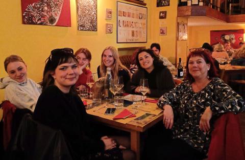 De vijf studenten praten na in een bar samen met de begeleidende lector